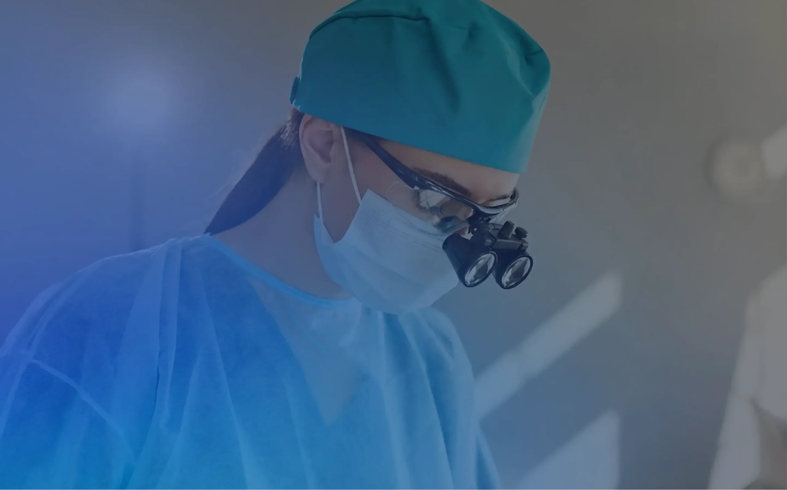 Doctor wearing surgical attire and magnifying loupes, representing procedure-focused website content.